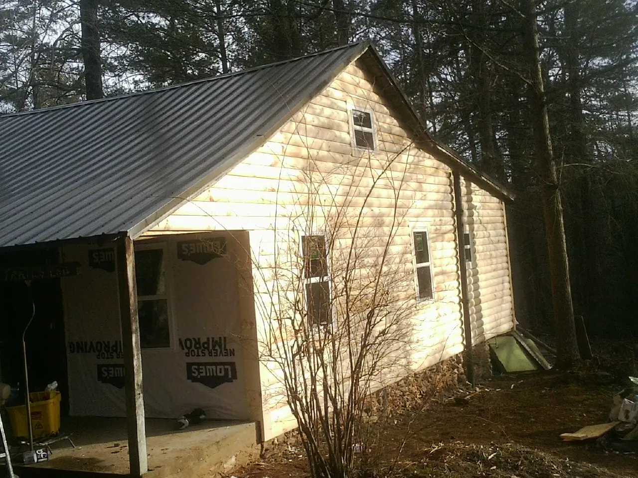 Log siding gable end under a dark metal roof edge in Pinnacle