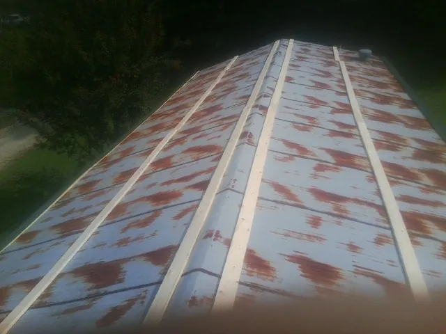 Rusted metal roof panels with new wood purlins before replacement — Storm Damage Roof Repair in Pinnacle by Roofing Brothers