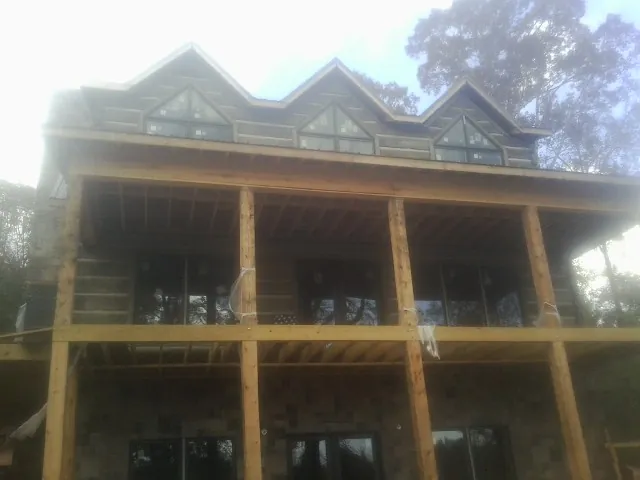 Dormers and porch framing on a large log home under construction — Roof Coating work by our crew in Pinnacle
