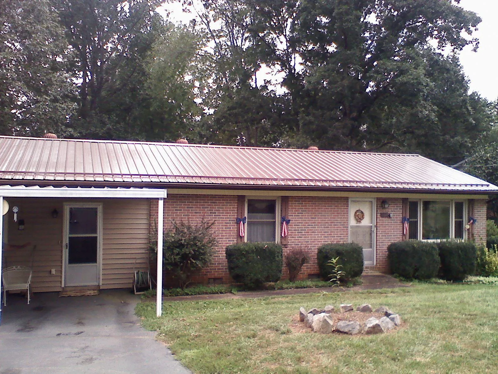 Bronze metal roof and carport on a brick ranch home — Roof Repair work by our crew in Pinnacle